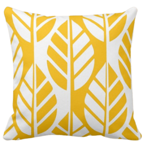 Yellow throw pillow with white leaves pattern