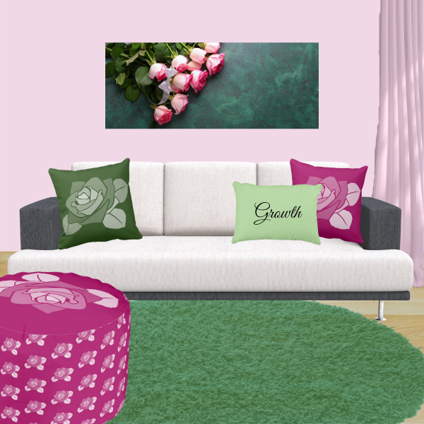 Pink and green pillows with rose pattern decorating a couch in charcoal and off-white.