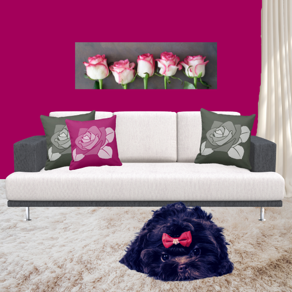 Pink and grey pillows with rose pattern decorating a couch in charcoal and off-white.