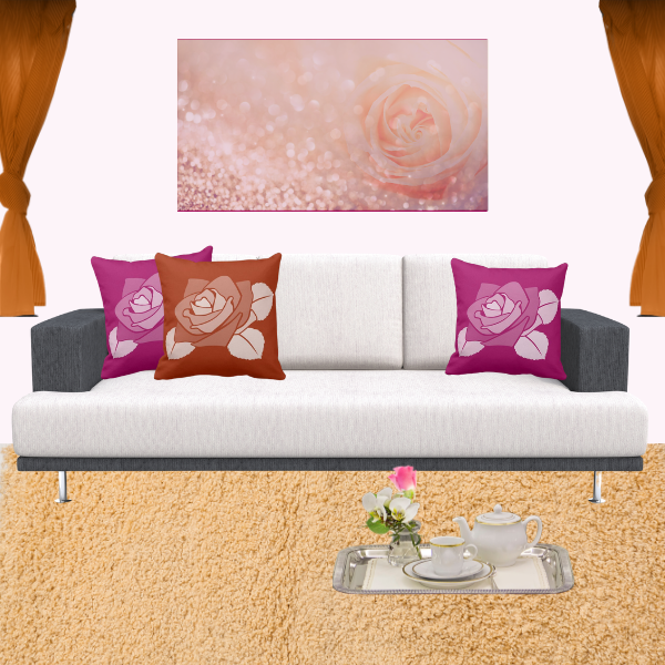 Pink and orange pillows with rose pattern decorating a couch in charcoal and off-white.