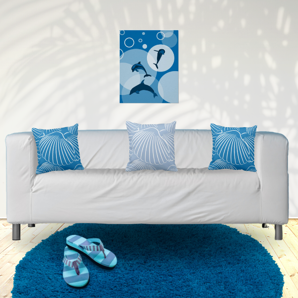 Coastal home decor with a dolphin poster print and blue pillows with shell pattern